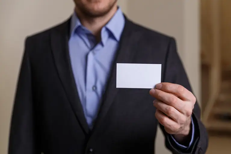 A man holding a blank business card
