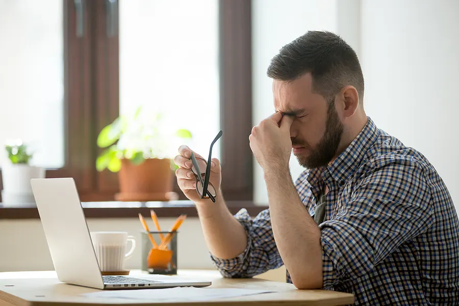 A stressed out man working at a laptop